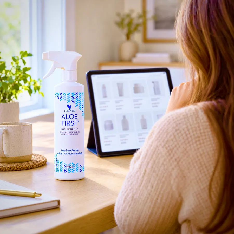 Flacon de Aloe First pe masă, lângă o tabletă cu rezultate de căutare într-un magazin online